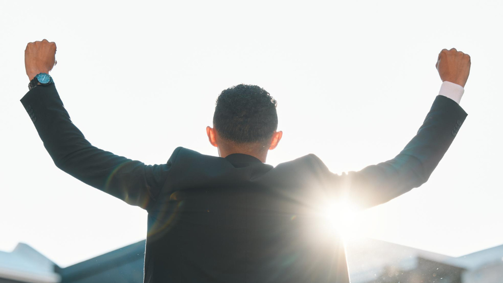 Agente de seguros celebrando el logro de sus objetivos con actitud de éxito y crecimiento profesional